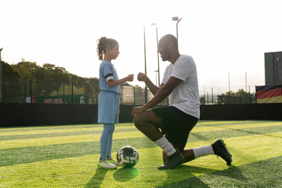 Soccer coach with young athlete